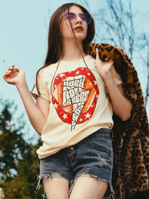 young woman wearing vintage style 70s retro rock and roll graphic t shirt with leopard skin jacket and ripped jeaans shorts