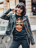 Edgy woman wearing studded black leather jacket and joshua tree graphic t shirt in an urban setting